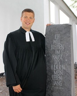Pfarrer Stefan Bürger am kunstvoll gestalteten Stein. / Foto: Malte Bürger